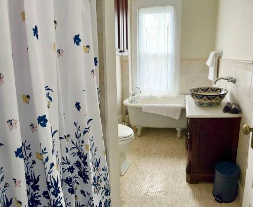 a bathroom with a shower curtain with a toilet and a tub at Vintage Charm: Annapolis Retreat in Annapolis