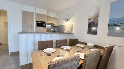 une salle à manger avec une table et des chaises et une cuisine dans l'établissement Argousiers 113, à Fort-Mahon-Plage