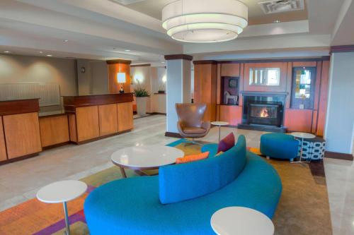 a living room with a blue couch and tables at Fairfield Inn & Suites by Marriott Mobile Daphne/Eastern Shore in Spanish Fort