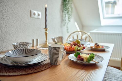 a table with plates of food and cups on it at LIVING Apartments / FeWo Neuwied in Neuwied