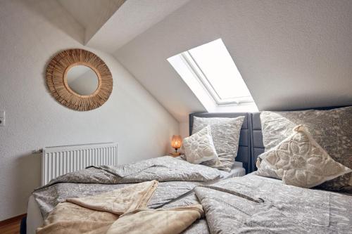 a attic bedroom with two beds and a mirror at LIVING Apartments / FeWo Neuwied in Neuwied