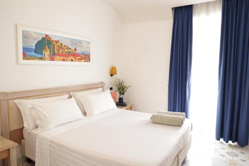 sypialnia z białym łóżkiem i oknem w obiekcie Hotel Terme Oriente - Beach & SPA w mieście Ischia