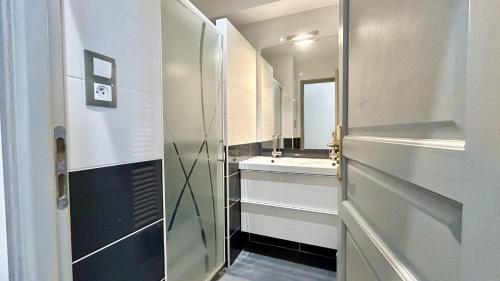 une salle de bain avec un lavabo et un miroir dans l'établissement Les bateaux, duplex 4 personnes proche plage, au Crotoy