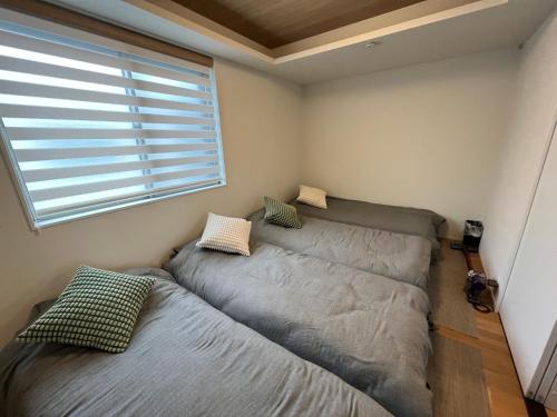 two beds in a room with a window at 嵐山 天龍の宿 New Open一棟貸切Private Villa,Arashiyama Central,Togetsu bridge 徒歩5min in Shimo saga