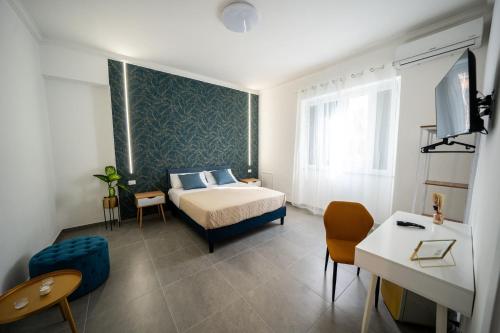 een slaapkamer met een bed, een bureau en een tv bij Luna Marie in Palermo