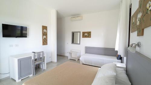 Biały salon z kanapą i telewizorem w obiekcie Agrialbergo Capalbio w mieście Capalbio