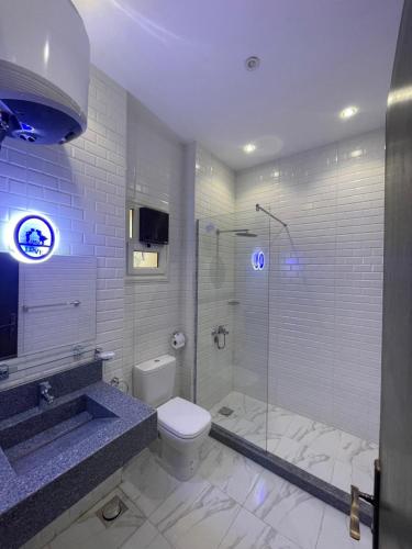 a bathroom with a toilet and a glass shower at Hola Cairo Boutique in Cairo