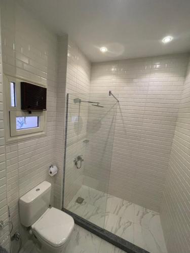a white bathroom with a shower and a toilet at Hola Cairo Boutique in Cairo