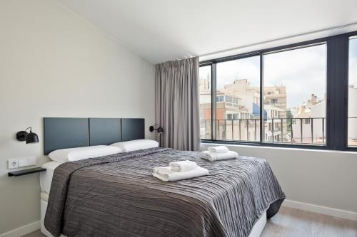 a bedroom with a bed and a large window at Sitges Vibe Apartments by Olala Homes in Sitges
