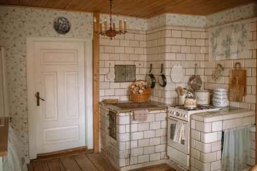 una cocina antigua con fogones y puerta en Siedlisko Niezapominajka - domek z basenem i balią, 