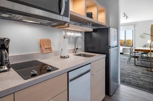 a kitchen with a sink and a refrigerator at TownePlace Suites By Marriott Wrentham Plainville in Wrentham