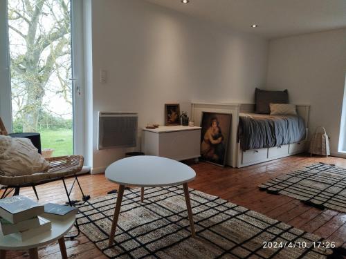 un salon avec un lit et une table dans l'établissement Grande et belle maison normande, à Martragny