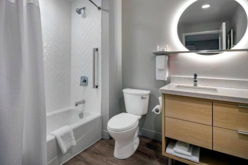 a bathroom with a toilet and a sink and a mirror at TownePlace Suites By Marriott Wrentham Plainville in Wrentham