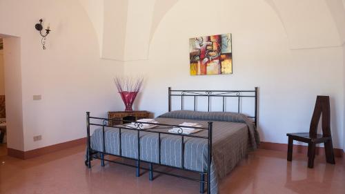 パンテレリアにあるVineyard View, Garden & Barbecue - Authentic "Dammusi"のベッドルーム1室(ベッド1台付)が備わります。壁に絵が飾られています。