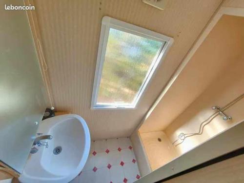 une salle de bain avec un lavabo et une fenêtre dans l'établissement GORGES DU VERDON CAMPING 3 etoiles PROCHE DU LAC DE STE CROIX NBRES ACTIVITES NAUTIQUES RANDONNEES ENTOURE DE CHAMPS DE LAVANDES 4 PERS, à Sainte-Croix-de-Verdon