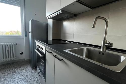 a kitchen with a sink and a stainless steel refrigerator at Marilyn’s Home [Wi-Fi - Netflix] in Rozzano
