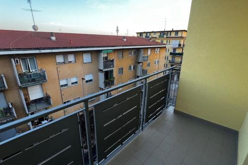 an apartment balcony with black doors and buildings at Marilyn’s Home [Wi-Fi - Netflix] in Rozzano