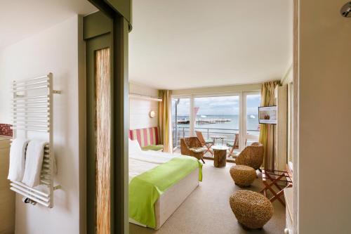 ヘルゴラントにあるHotel Rickmers' Insulanerのベッドとバルコニー付きのホテルルーム