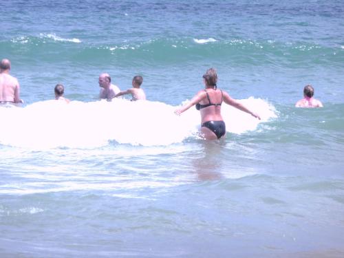 a woman in a bikini standing on a surfboard in the ocean at STUDIO DELUXE IN MARINA CAPE 4 stars complex 33 7 in Aheloy