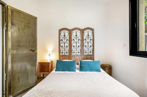 a bedroom with a bed with two blue pillows at Maison, centre ville, terrasse, parking, calme in Sète