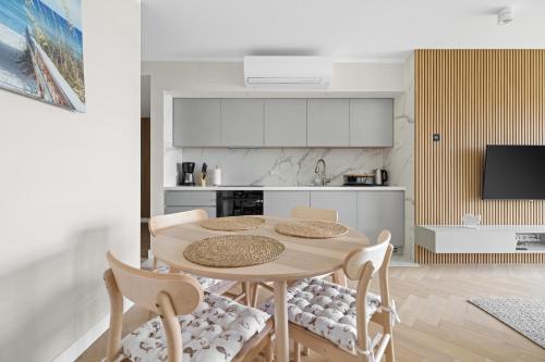a kitchen with a table and chairs in a room at Solaris Darłówko Premium Emilia Strupiechowska in Darłowo