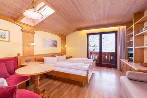 Pokój z łóżkiem, stołem i kanapą w obiekcie Berghof - T&T w mieście Reit im Winkl