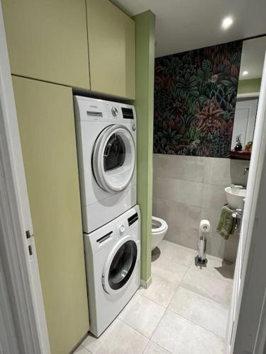 une salle de bain avec machine à laver et toilettes dans l'établissement Vue Tour Eiffel - calme & chic, à Paris