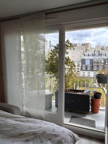 une chambre avec vue sur une ville depuis une fenêtre dans l'établissement Vue Tour Eiffel - calme & chic, à Paris