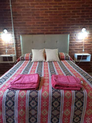 a bed with two pillows on it in a room at 4 Estaciones in Pergamino