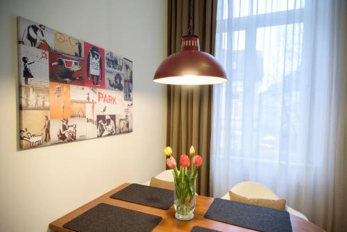 einen Esstisch mit einer Vase aus Blumen und einer Lampe in der Unterkunft Boardinghouse Luise 5 in Heidelberg