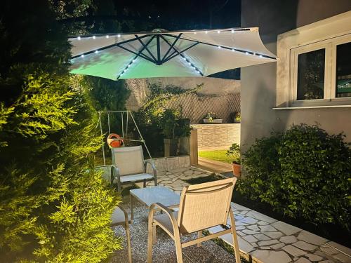a patio with chairs and a table under a umbrella at eliTe deluxe 1 in Kavala