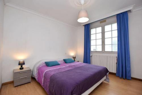 Schlafzimmer mit einem lila Bett und blauen Vorhängen in der Unterkunft « La tranquillité » Villa avec piscine in Saint-Hilaire-de-Riez