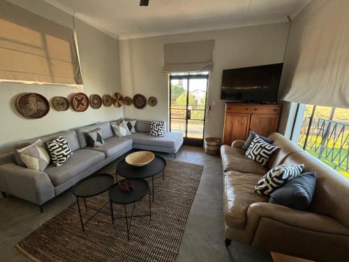 sala de estar con 2 sofás y TV en Leopard Rock, en Otjiwarongo