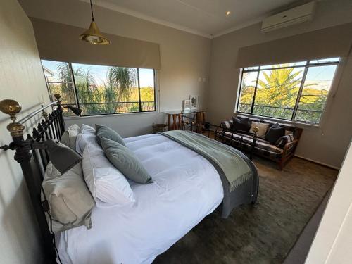 una camera con un grande letto e due finestre di Leopard Rock a Otjiwarongo