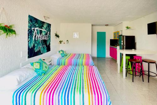 a bedroom with a bed with a colorful striped bedspread at Seaside Escape Studio in Cancun Beach in Cancún