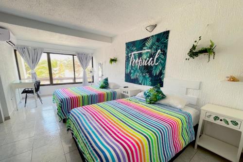 a bedroom with two beds and a table and a sign on the wall at Seaside Escape Studio in Cancun Beach in Cancún