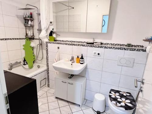 ein Badezimmer mit einem Waschbecken, einem WC und einer Badewanne in der Unterkunft Private room with large bed -Netflix and projector in Frankfurt am Main