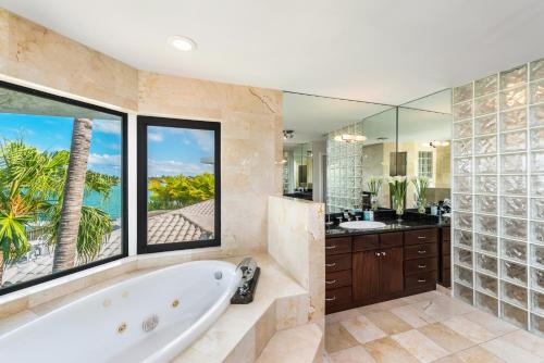 ein Bad mit einer Badewanne und einem großen Fenster in der Unterkunft Discover Serenity by the See Your Exclusive Miami Beach Escape! in Miami