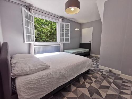 um quarto com uma cama grande e uma janela em Lège-Bourg : Maison typique landaise avec piscine em Lège-Cap-Ferret