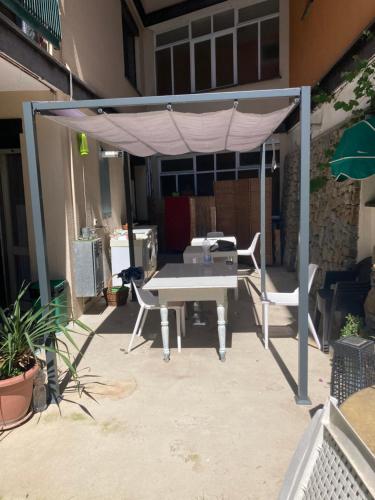 a picnic table under a canopy on a patio at GUEST HOUSE BERZEFI in Bergeggi
