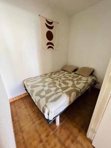 une petite chambre avec un lit dans une pièce dans l'établissement T2 ,4 couchages ,Climatisé ,Terrace ,en face d'Aqualand ,plage Rochelongue, au Cap d'Agde
