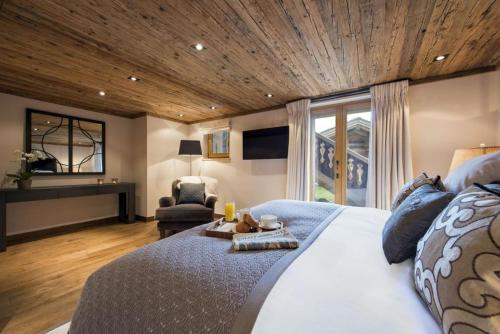 a bedroom with a large bed with a wooden ceiling at Luxury Apartment in Crans Montana by Dieckereise in Crans-Montana