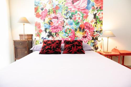 um quarto com uma cama grande e uma cabeceira floral em ALBOSCRIU - Duplex con piscina y barbacoa em Deltebre