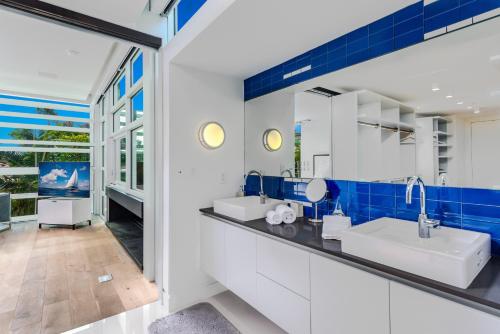 een badkamer met 2 wastafels en blauwe tegels bij Indulge in Waterfront Elegance Your Ultra Luxury Miami Beach Estate Beckons! in Miami
