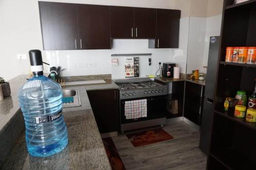 a bottle of water sitting on top of a kitchen counter at Modern 2BR Sanctuary, Pool & Gym in Nairobi