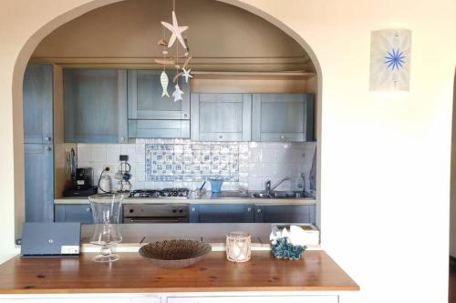 cocina con armarios azules y encimera de madera en Villa Vianello Piscina privata, en Stintino