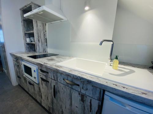 a kitchen with a sink and a microwave on a counter at Chez GABRIEL in Rodez