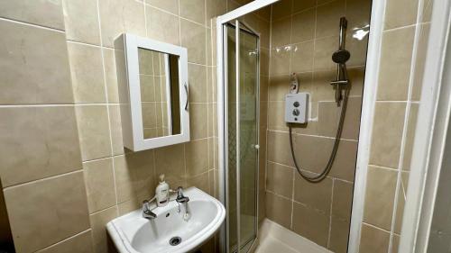 a bathroom with a sink and a shower at Cosy flat Fulham Broadway in London