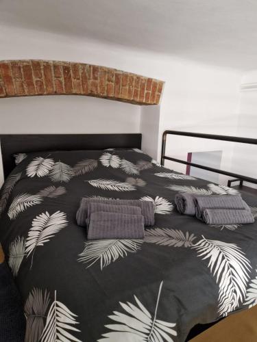 a bed with a black and white comforter with pillows at Apartment Navigli Milano in Milan