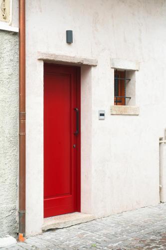 a red door on the side of a building at La Casa del Ciliegio in Feltre